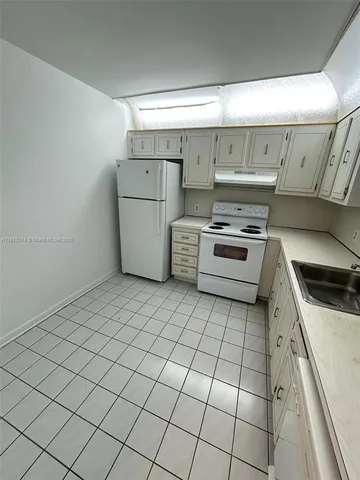 a kitchen with a stove top oven and cabinets