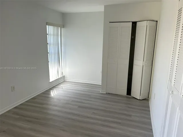 an empty room with wooden floor and entrance