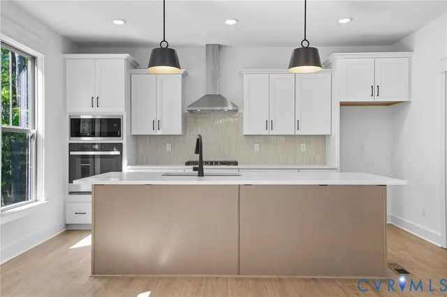 a kitchen with stainless steel appliances granite countertop a sink a stove and a refrigerator