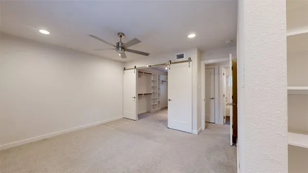 en empty room with a ceiling fan and glass door