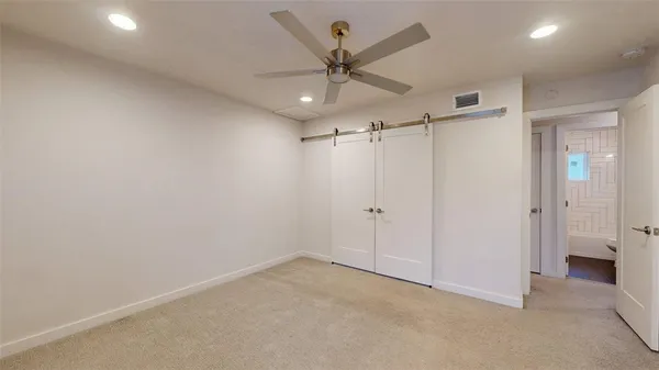an empty room with a ceiling fan and a window