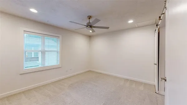 an empty room with a window and a fan