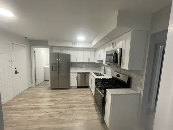 a kitchen with a refrigerator stove and wooden cabinets