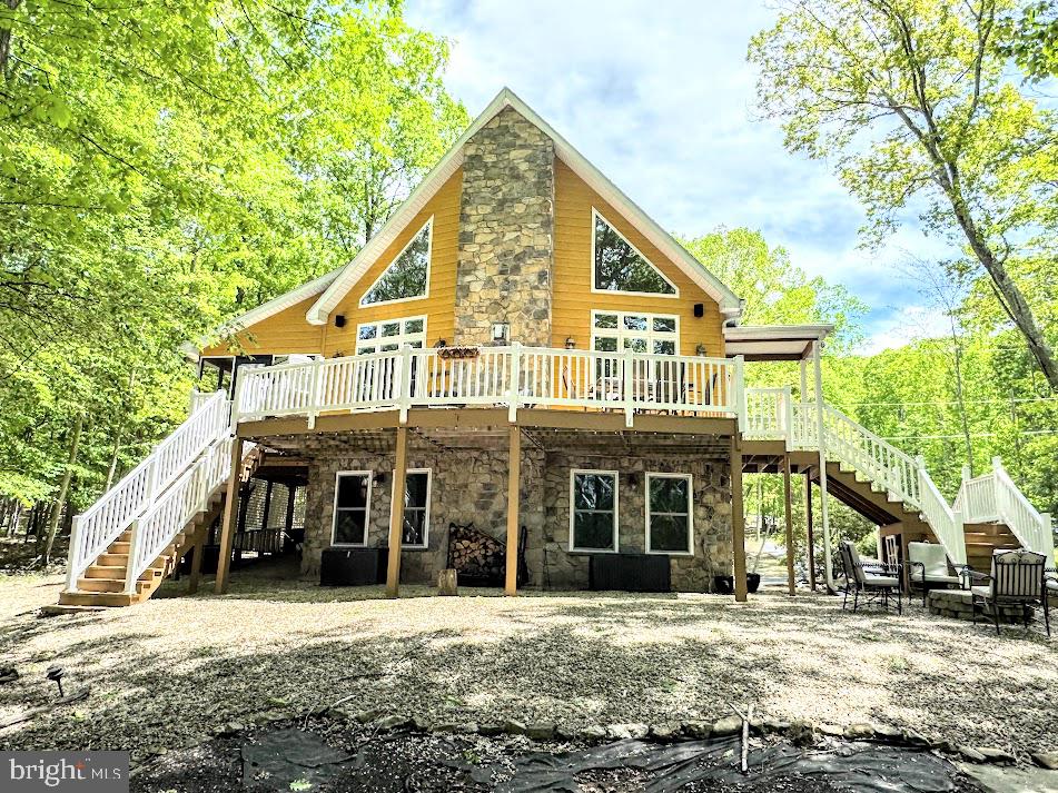 a view of a big house with large windows and a large tree