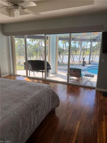 a spacious bedroom with a large window and a balcony