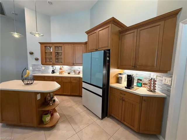 a kitchen with stainless steel appliances kitchen island granite countertop a stove top oven a sink dishwasher and a refrigerator with wooden floor