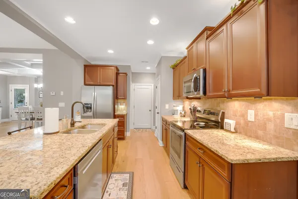 a kitchen with stainless steel appliances granite countertop wooden cabinets a sink and dishwasher