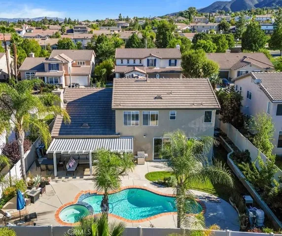 an aerial view of a house with yard and green space