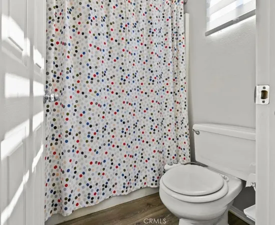 a bathroom with a toilet and a shower curtain