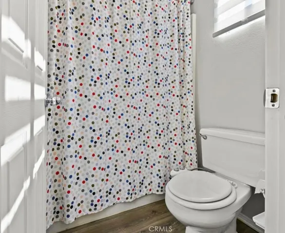 a bathroom with a toilet and a shower curtain
