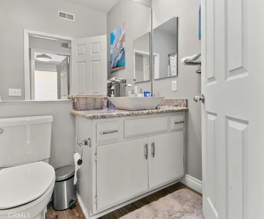 a bathroom with a granite countertop toilet sink and mirror