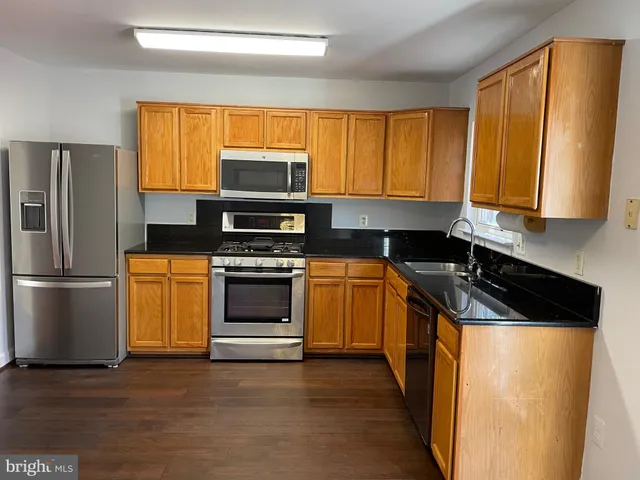 a kitchen with a stove a sink and a refrigerator