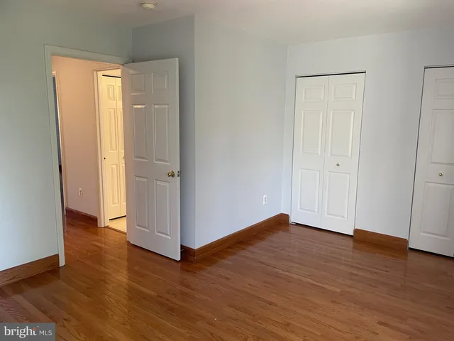 an empty room with wooden floor and closet