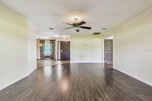 a spacious bedroom with a bed a couch and a chandelier