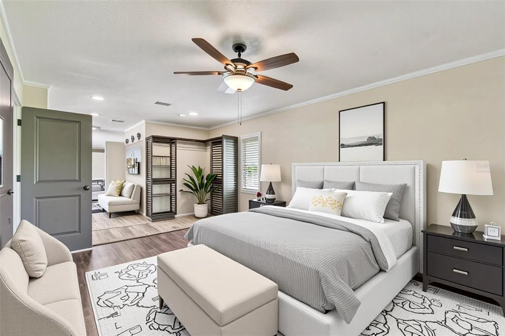 5319 Saddlebrook Way Wesley Chapel, FL 33543 - Photo 19 of 77 a spacious bedroom with a bed a couch and a chandelier