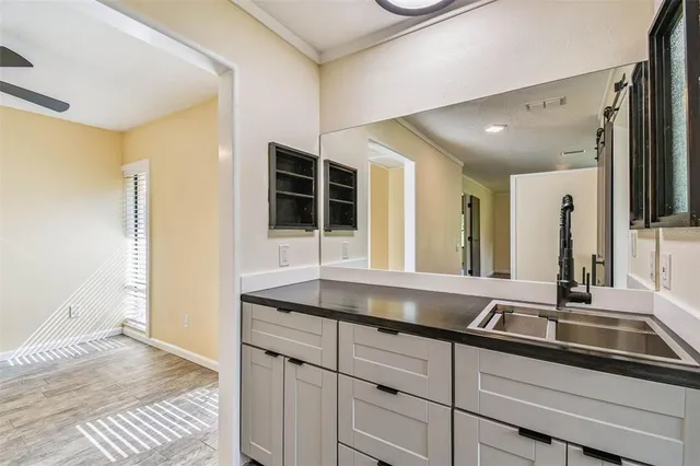 a kitchen with stainless steel appliances granite countertop a stove top oven a sink dishwasher a refrigerator and a fireplace with wooden floor