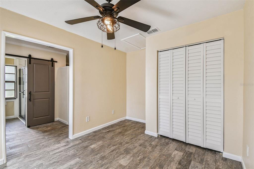 5319 Saddlebrook Way Wesley Chapel, FL 33543 - Photo 28 of 77 an empty room with wooden floor chandelier fan and closet in a room