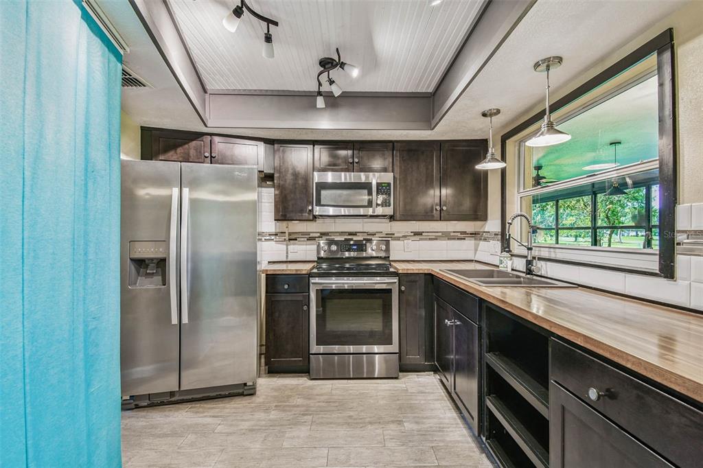 5319 Saddlebrook Way Wesley Chapel, FL 33543 - Photo 31 of 77 a kitchen with stainless steel appliances granite countertop a sink stove and refrigerator