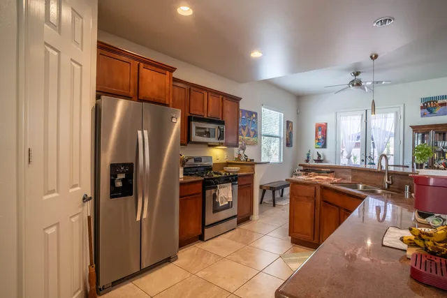 a kitchen with stainless steel appliances granite countertop a refrigerator stove and sink