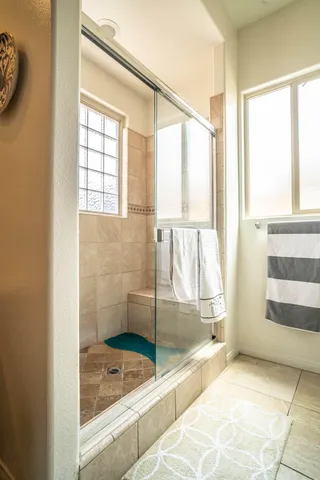 a bedroom with a bed and a lamp on dresser