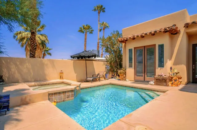 a view of a house with swimming pool and sitting area