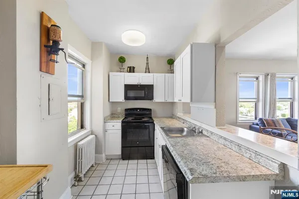 a kitchen with granite countertop a sink stove and refrigerator
