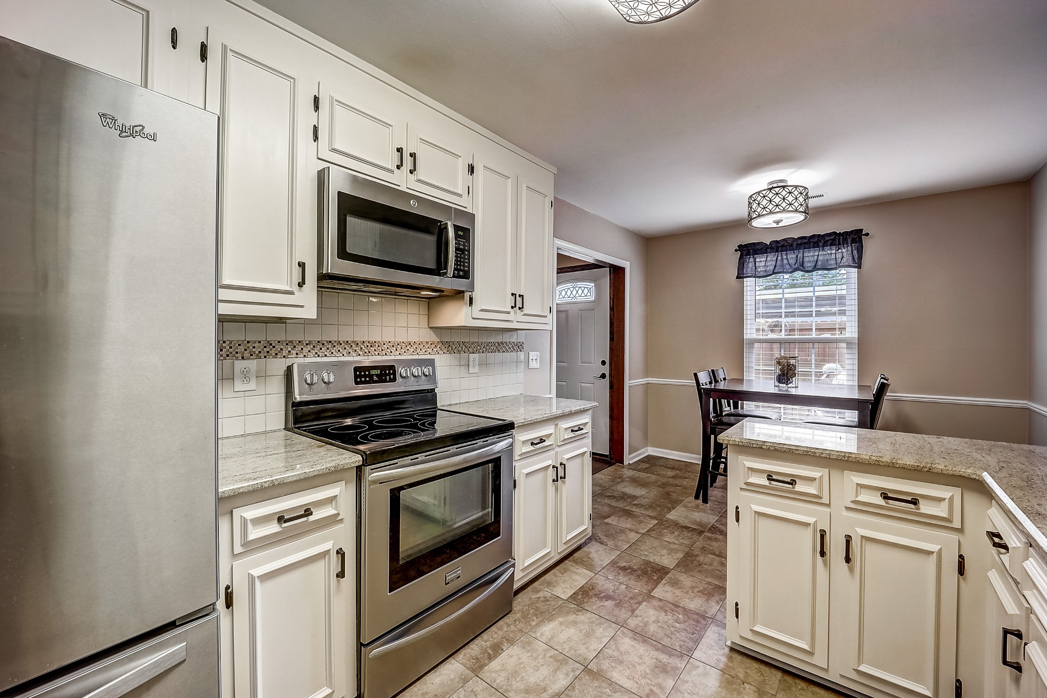 922 General George Patton Road Nashville, TN 37221 - Photo 12 of 30 a kitchen with stainless steel appliances granite countertop white cabinets a stove top oven a sink and dishwasher