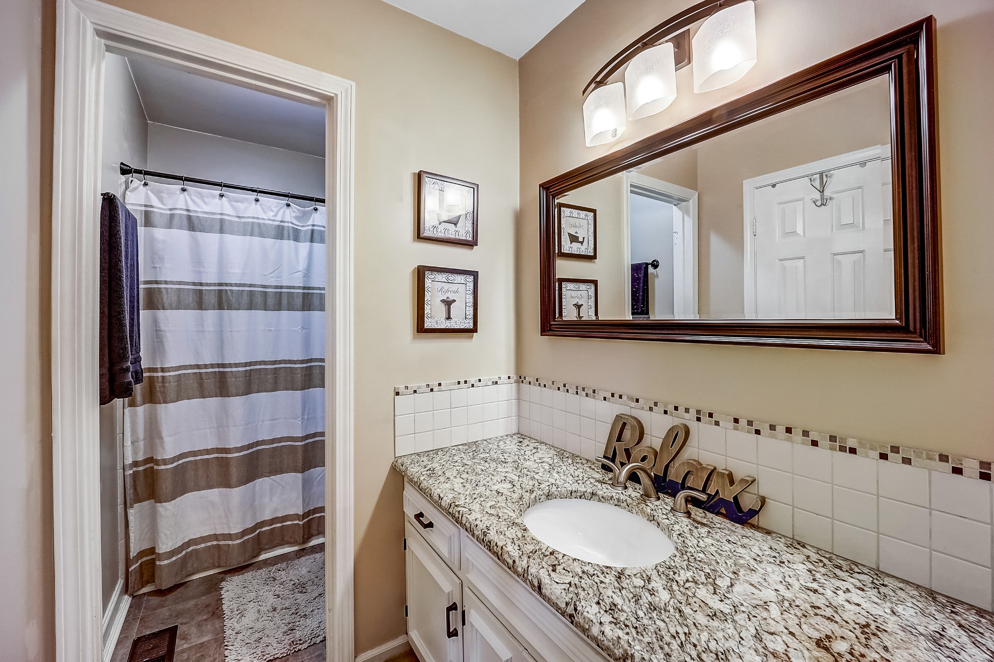 922 General George Patton Road Nashville, TN 37221 - Photo 15 of 30 a bathroom with a granite countertop sink a mirror a vanity and a shower