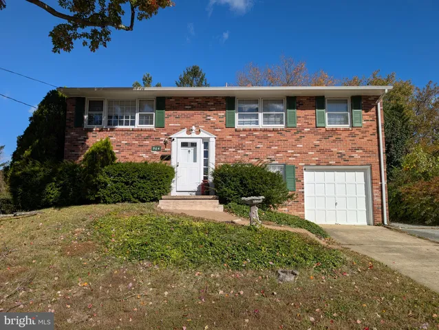 a front view of a house with a yard and potted plants