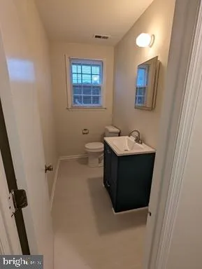 a bathroom with a sink and mirror with toilet