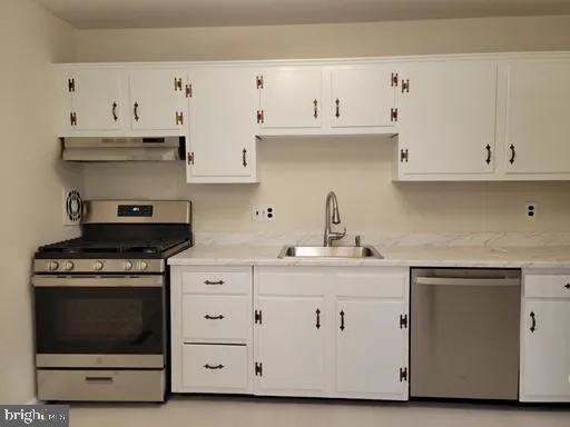 a kitchen with white cabinets and a stove