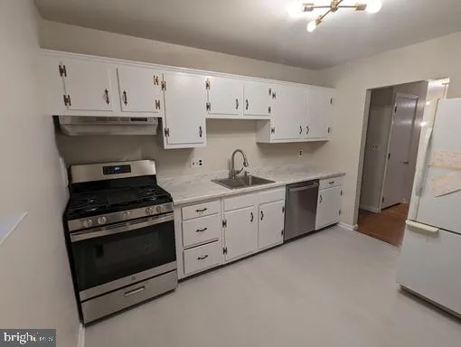 a kitchen with cabinets appliances and a sink