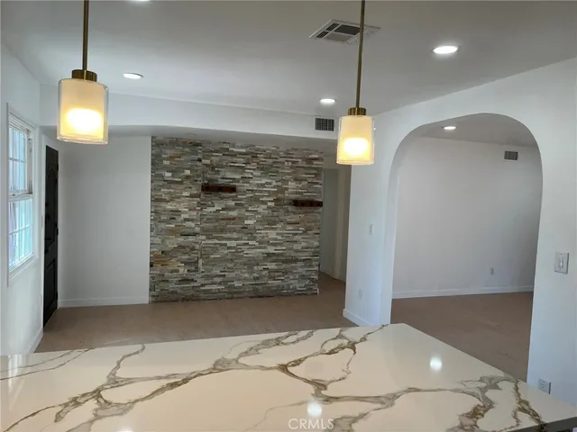 a room with a chandelier fan and a rug