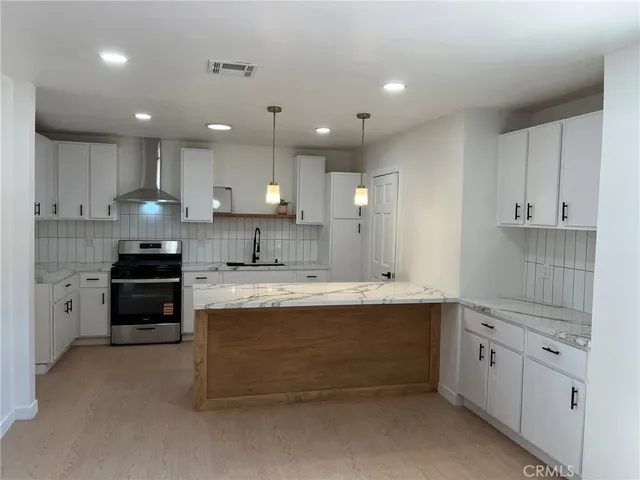 a large kitchen with stainless steel appliances kitchen island granite countertop a sink and cabinets