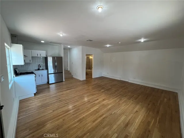 a view of a kitchen with a refrigerator and a stove top oven