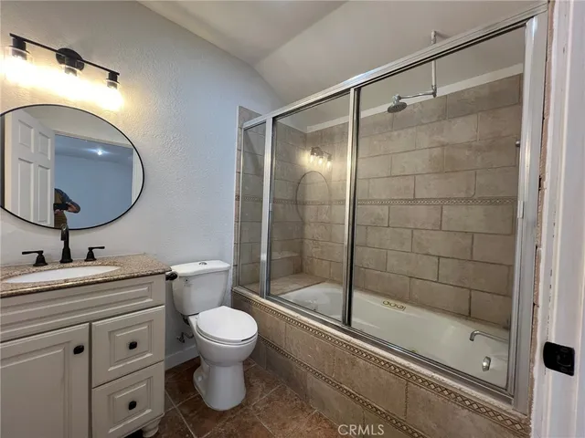 a bathroom with a shower sink mirror and toilet
