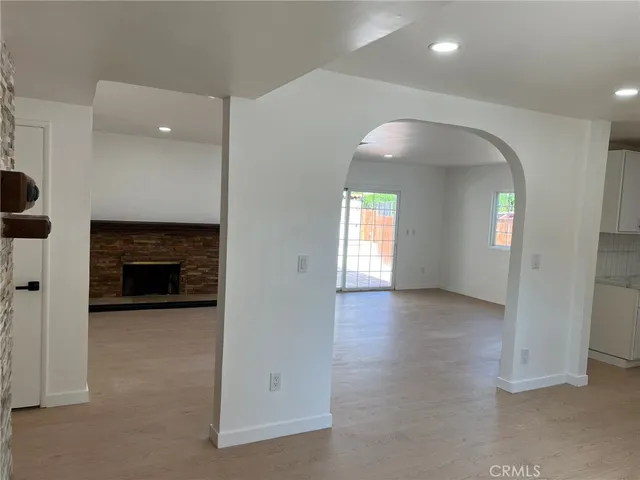 an empty room with windows and fireplace