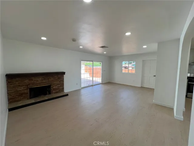 an empty room with windows and fireplace