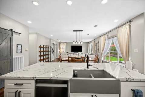 a kitchen with kitchen island white cabinets and stainless steel appliances
