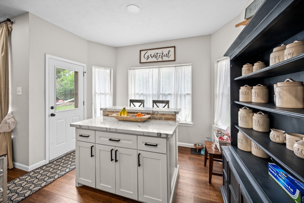 814 Legend Spring Drive Katy, TX 77494 - Photo 11 of 30 The breakfast nook features a second island with storage, breakfast bar seating and Quartz countertop for prep/serving. The bay window allows this space to be filled with natural light and from here you have views of the entire backyard.