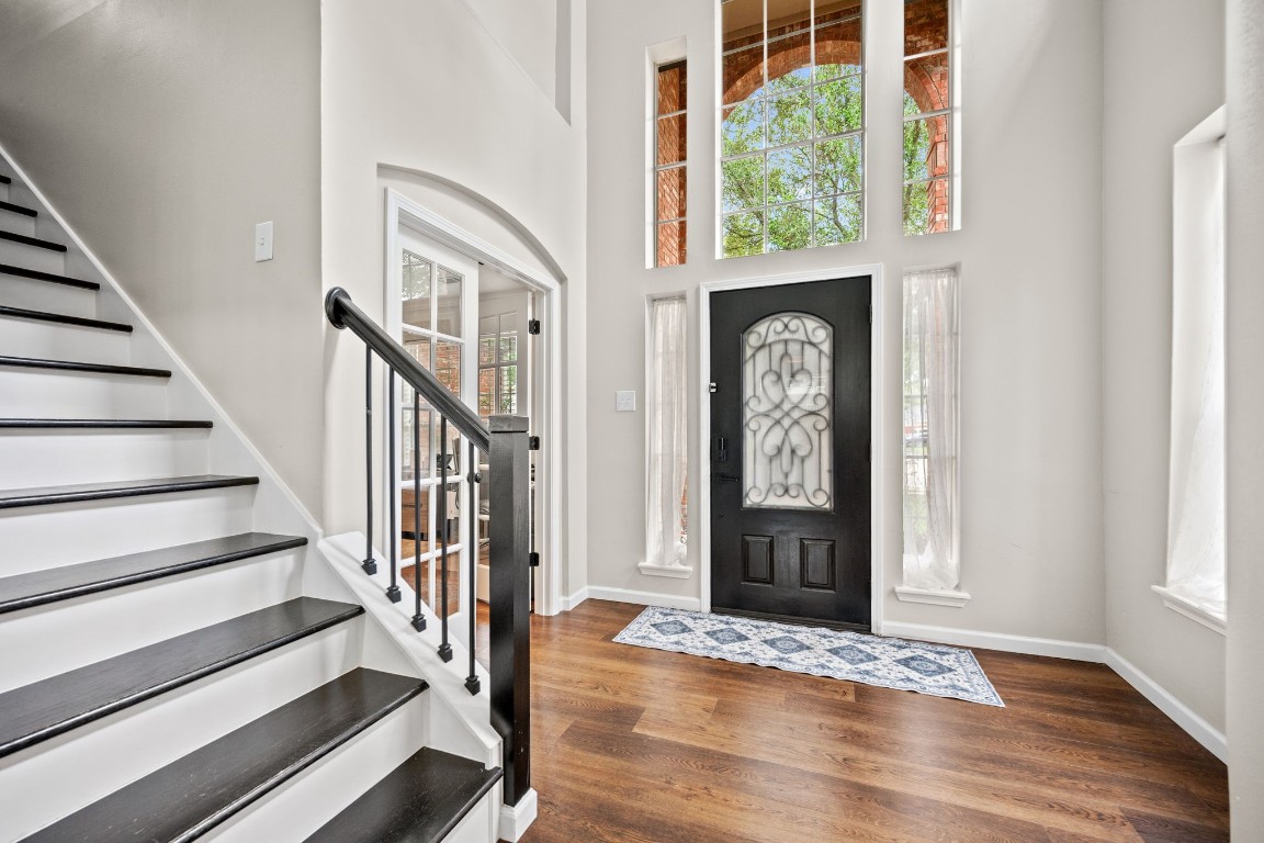 814 Legend Spring Drive Katy, TX 77494 - Photo 4 of 30 updated flooring and wood stair treads coordinate beautifully, accented by the wrought iron railing and natural light in the two-story entry.