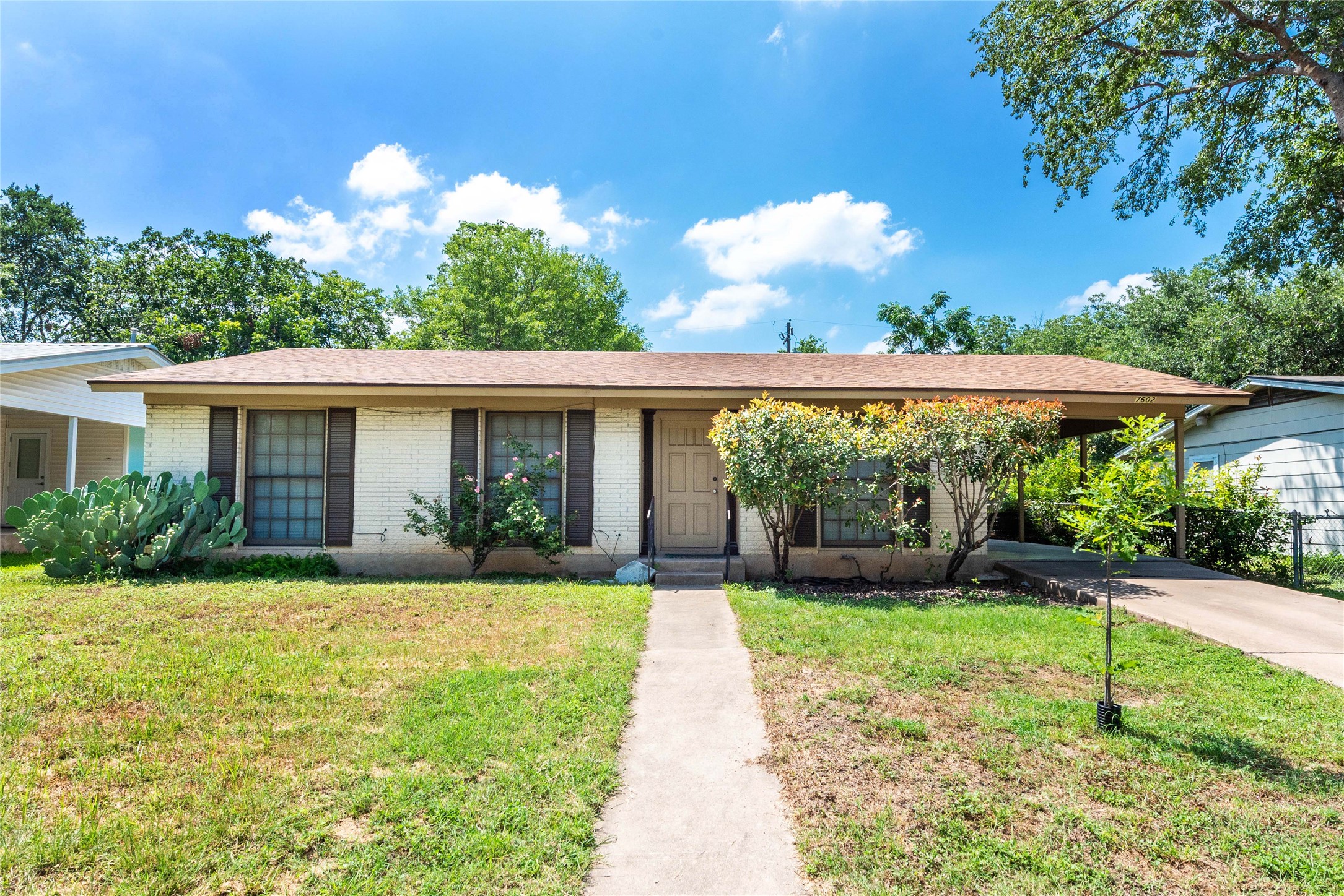 7602 Delafield Lane Austin, TX 78752 - Photo 1 of 17 A classic ranch home presents a welcoming facade with a simple landscape and practical driveway.