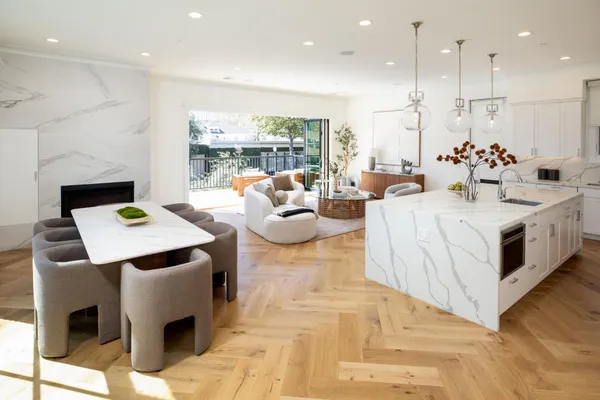 a kitchen with kitchen island a dining table chairs sink and cabinets