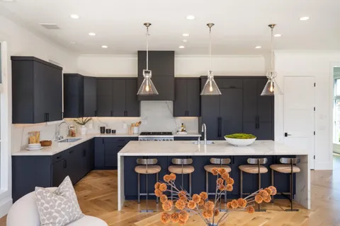 a kitchen with stainless steel appliances kitchen island granite countertop a sink and a stove