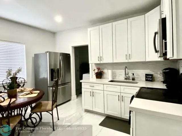 a kitchen with granite countertop a sink a stove a microwave and cabinets