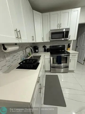 a bedroom with a bed tv and a mirror