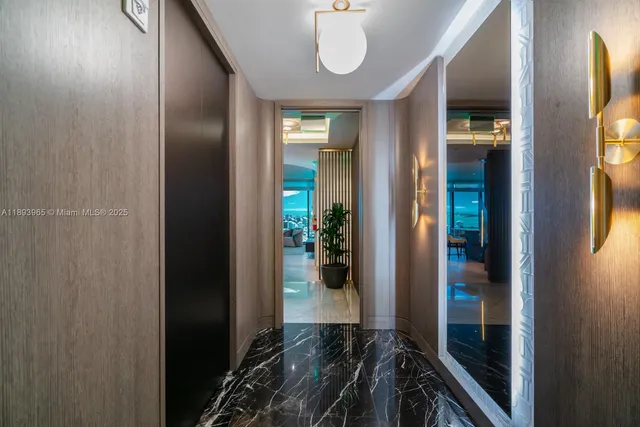 a view of a hallway with wooden floor and a bathroom