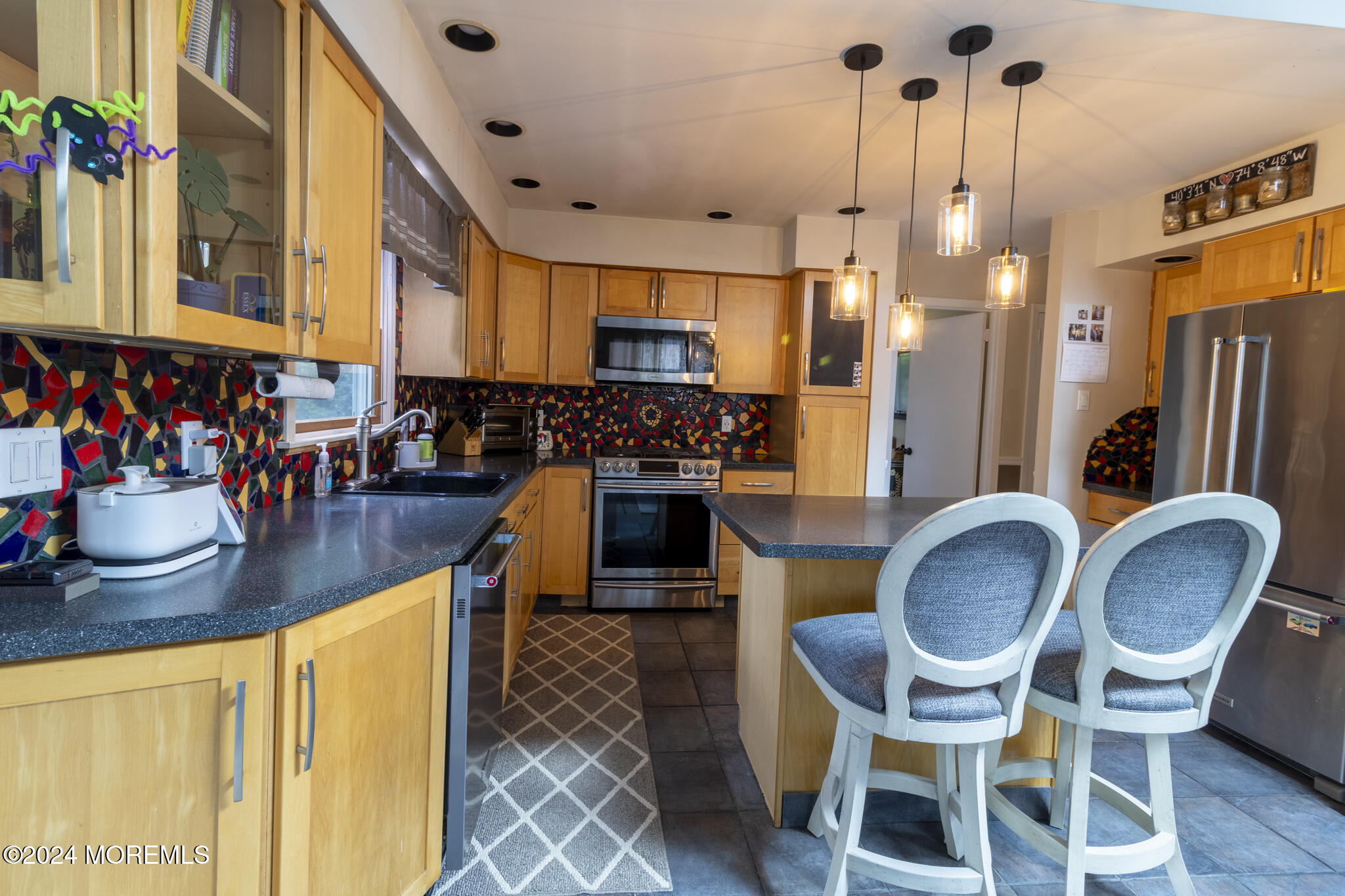 448 Cornell Drive Brick, NJ 08723 - Photo 4 of 28 a dining room with stainless steel appliances kitchen island granite countertop a table chairs and a refrigerator