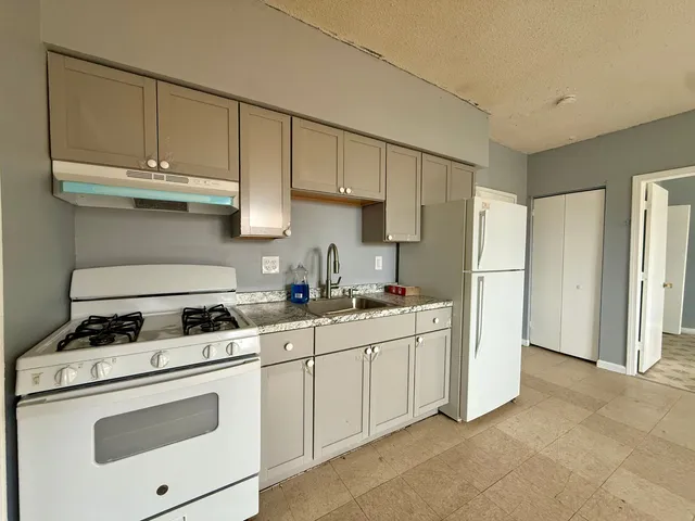 a kitchen with appliances a sink and cabinets