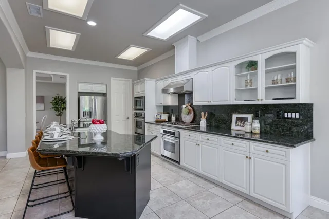 a kitchen with granite countertop a sink and cabinets